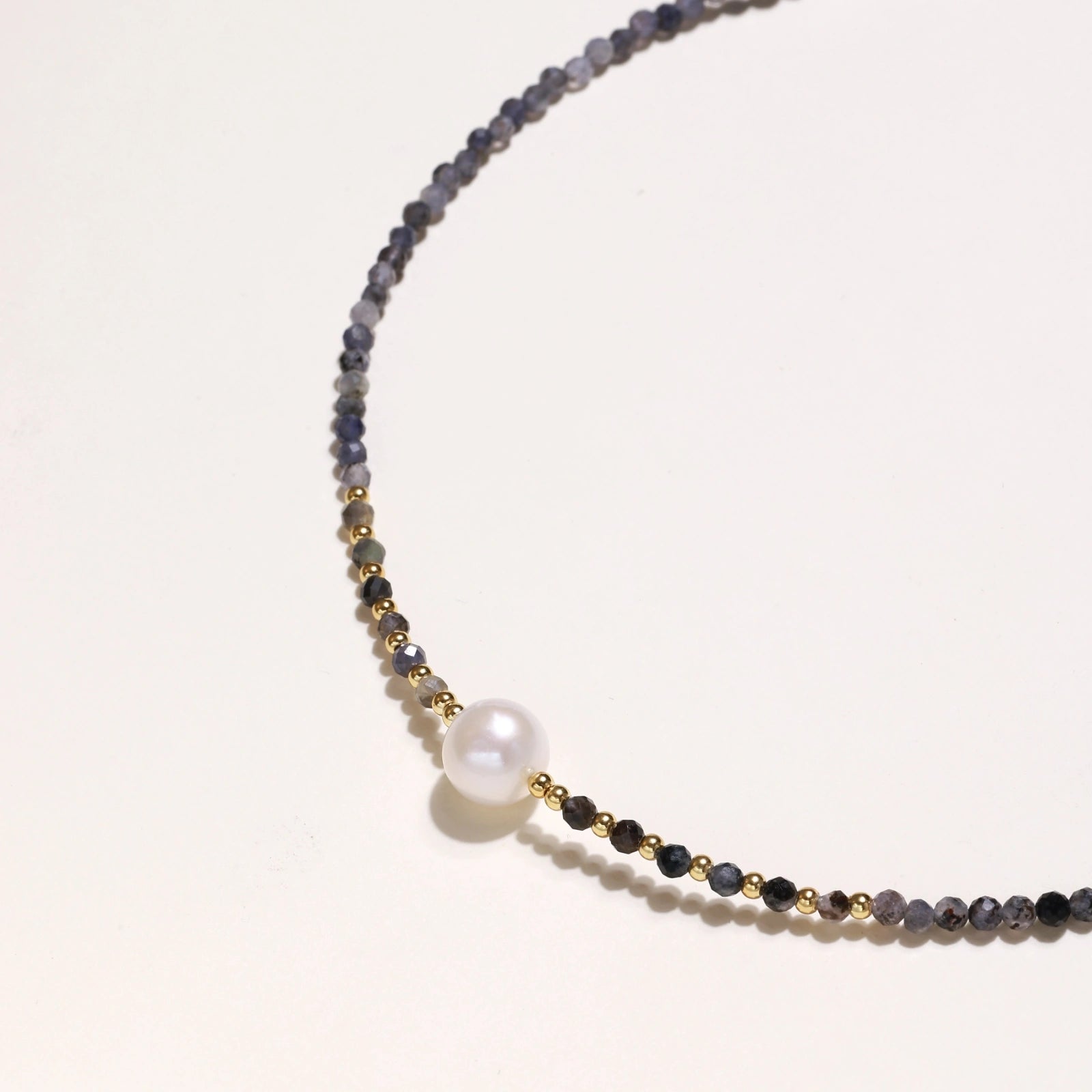 Dainty necklace with faceted purple iolite beads, gold vermeil accents, and central pink-white freshwater pearl.